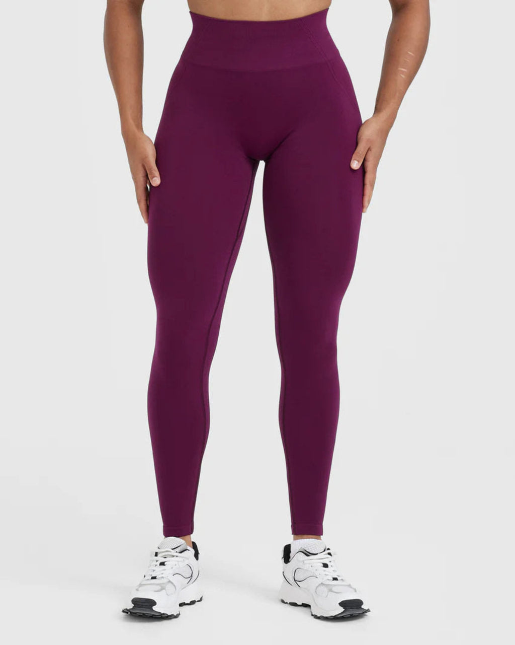 Person wearing purple leggings on a white background