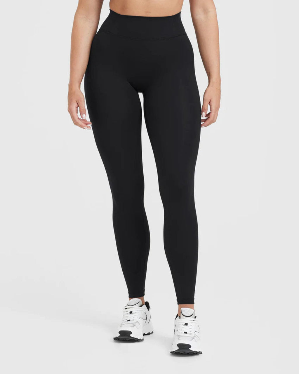 Person wearing black leggings on a white background