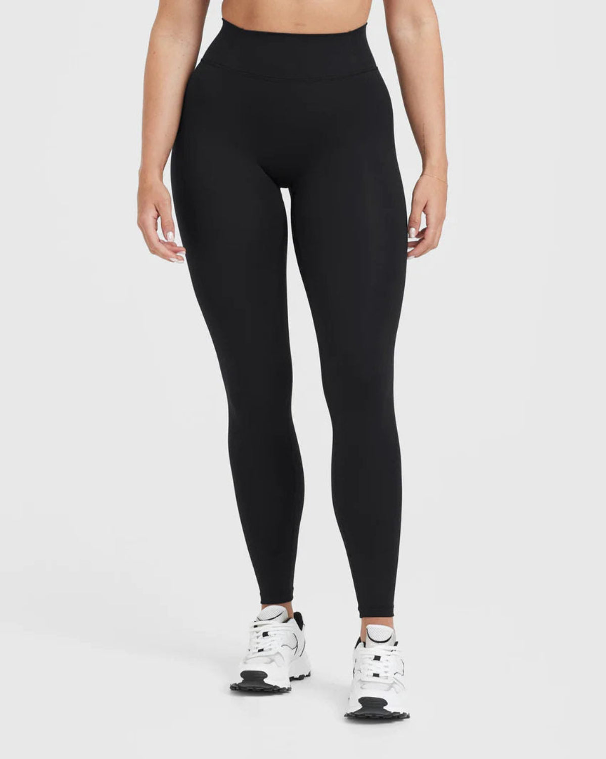 Person wearing black leggings on a white background
